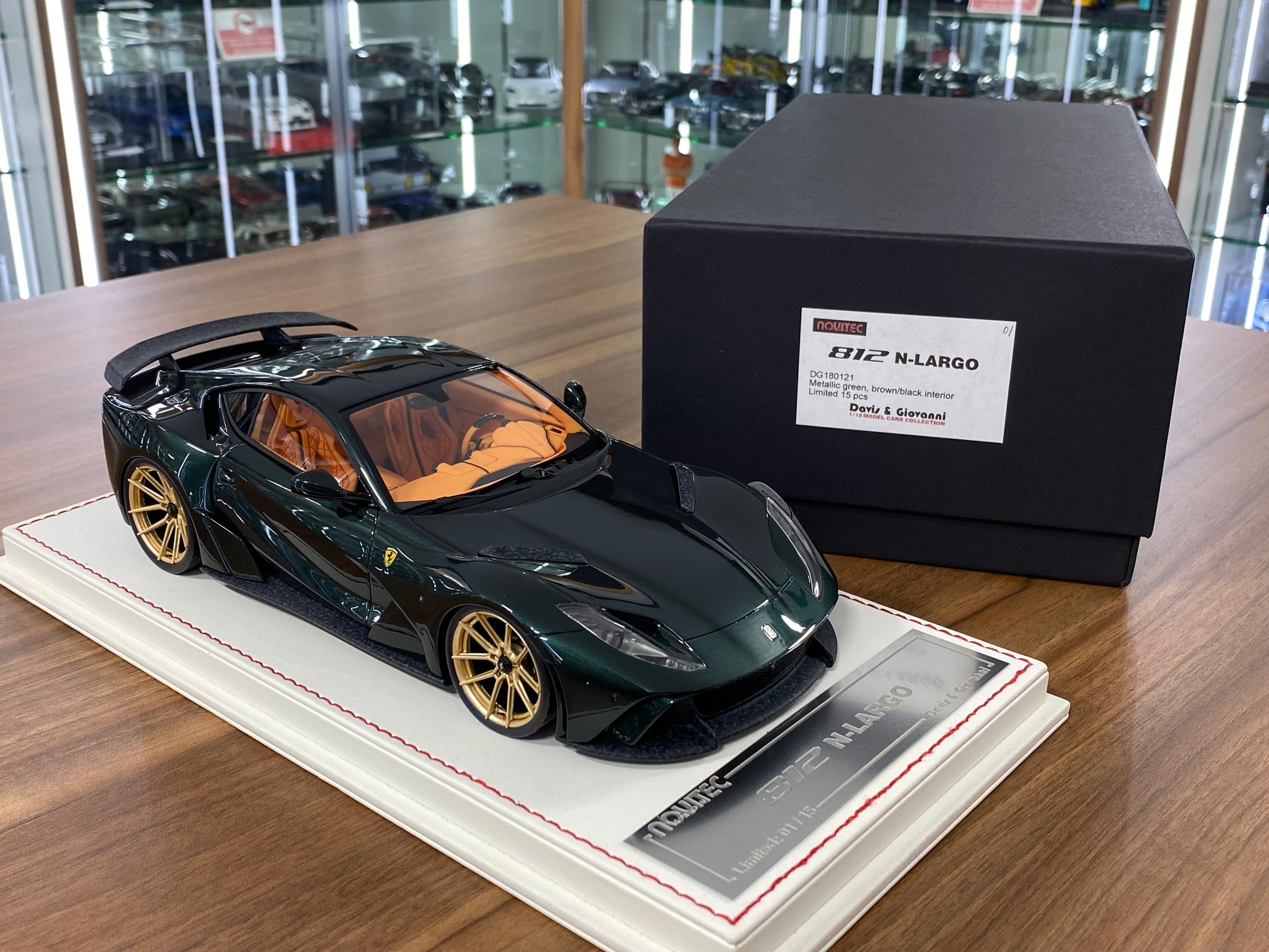 Model car on a display stand with a branded box in the background