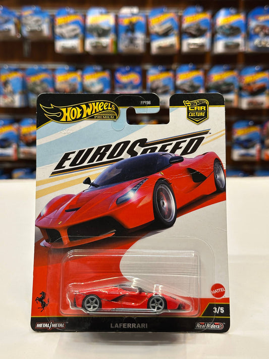A Hot Wheels EuroSpeed Mattel LaFerrari die-cast toy car in its original blister card packaging, displayed against a blurred background of other toy packages.